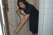 Gisela Antor begiest ihren augestreckten Arm in einer Dusche mit Wasser