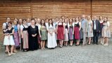 Gruppenfoto vor einer Holzwand.