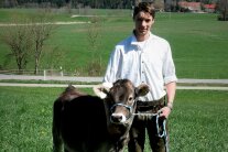 Ein junger Mann in Tracht mit einem Kalb