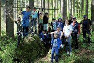 Gruppenfoto von Kindern und Erwachsenen im Wald