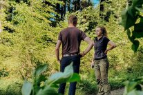 Eine Försterin und ein Mann unterhalten sich in einem Wald