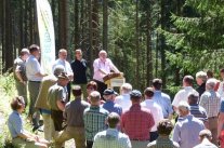 Teilnehmergruppe und Redner im Wald