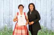 2 Frauen stehen nebeneinander und halten Urkunde