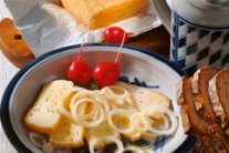 Steinbuscher mit Zwiebelringen und Radieschen auf einem Teller